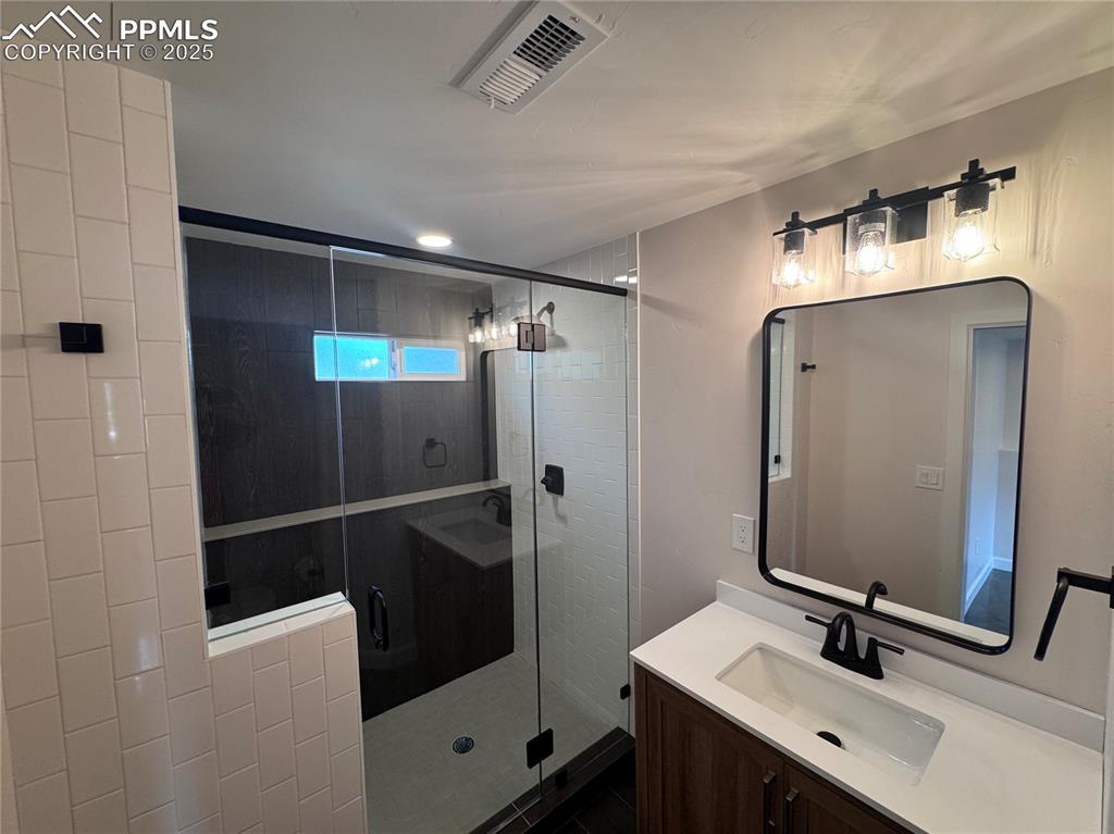 Image 31 of 36: Bathroom with vanity and a shower stall