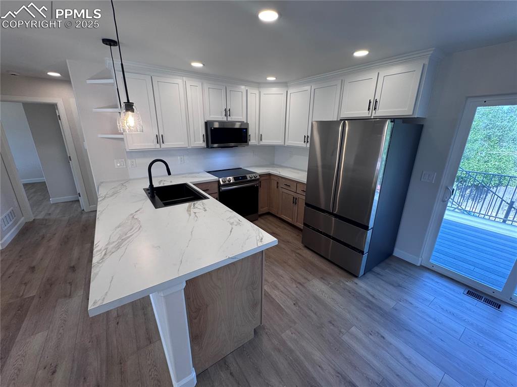 Image 7 of 36: Kitchen with a peninsula, stainless steel appliances, recessed lighting, wh