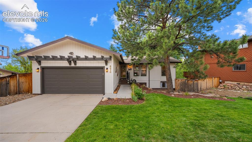 Image 1 of 50: Modern ranch-style home featuring a two-car garage with a pergola accent, c