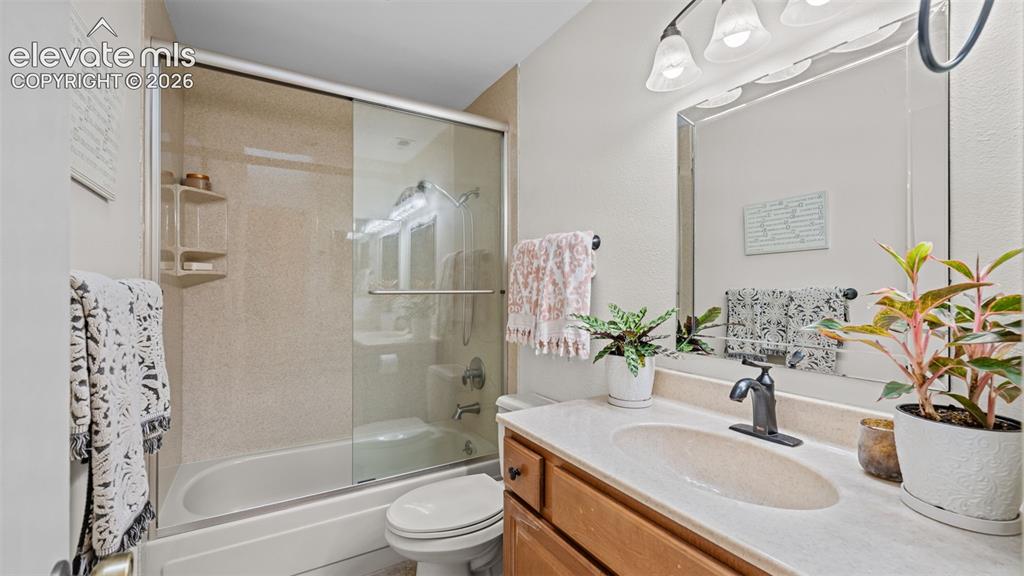Image 11 of 50: Bathroom featuring a tub and shower combination with sliding glass doors, a