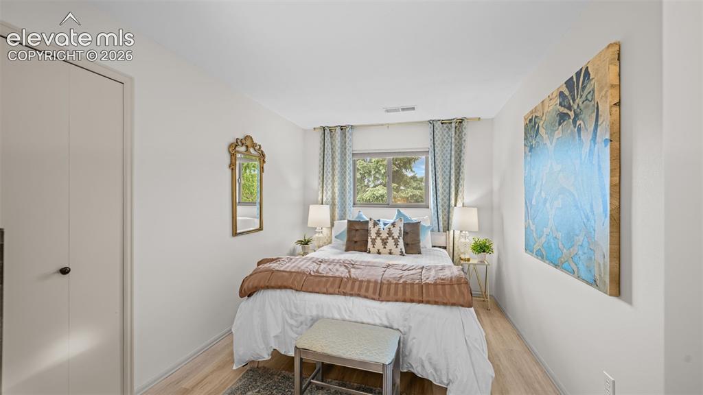 Image 12 of 50: Bedroom featuring light-tone wood-finish flooring