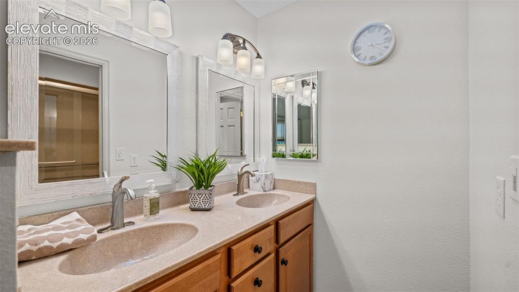 Image 16 of 50: Bathroom featuring a double vanity with integrated sinks, wood-finish cabin