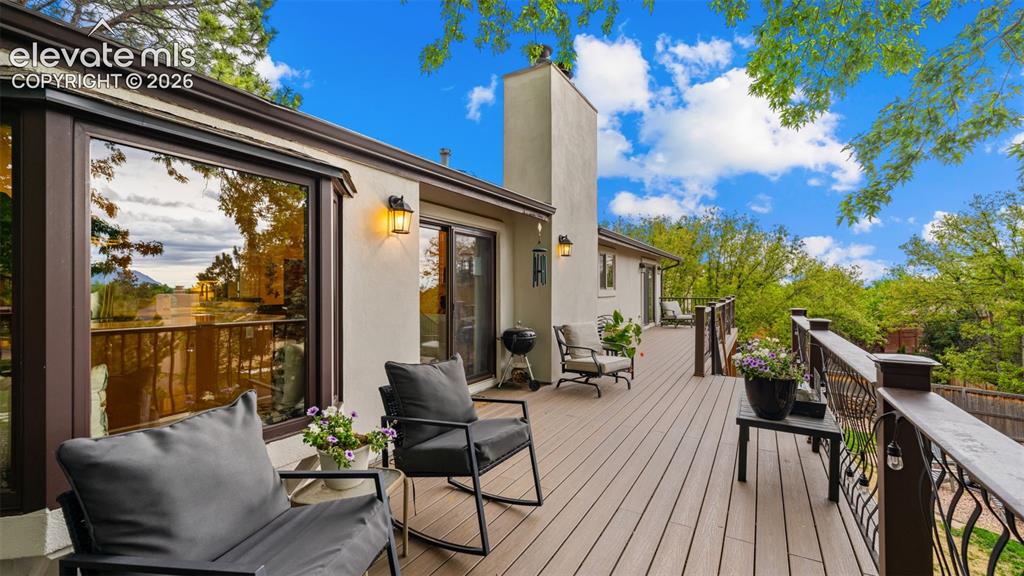 Image 18 of 50: Expansive outdoor deck featuring wood-finish flooring, stucco exterior, and