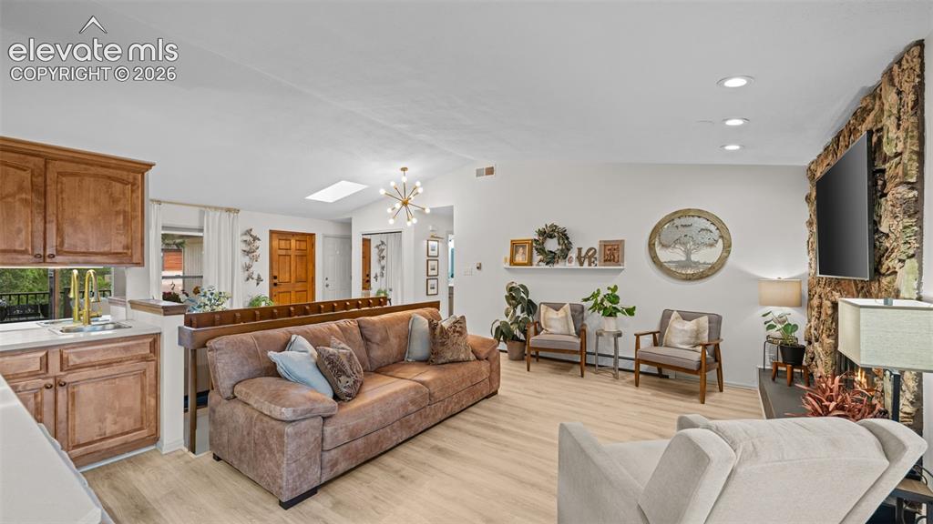 Image 21 of 50: Open-concept living area featuring light wood-finish flooring, a built-in w