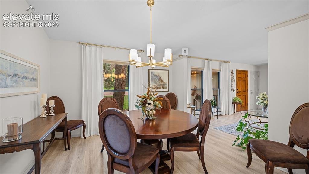 Image 24 of 50: Dining area featuring vaulted ceilings, light wood-finish flooring, and a m