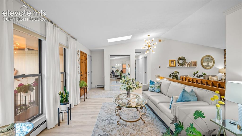 Image 27 of 50: Open-concept living area featuring a vaulted ceiling with skylight, light w