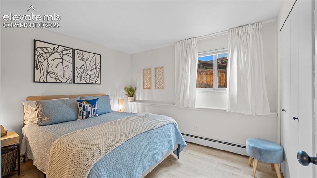 Image 36 of 50: Light wood-finish flooring complements the white walls and window treatment