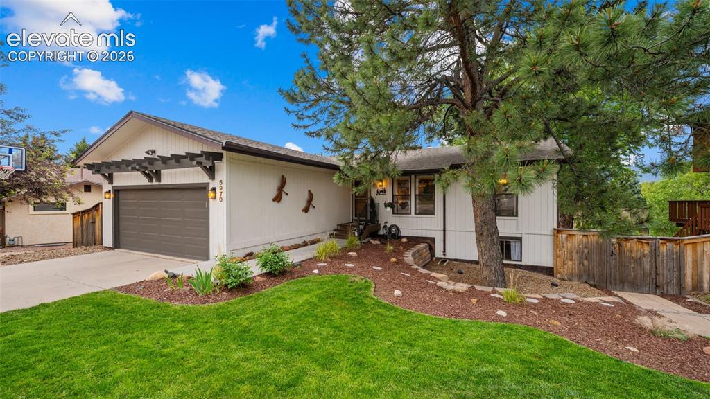 Image 4 of 50: Exterior featuring white vertical siding, a dark brown garage door, and a d