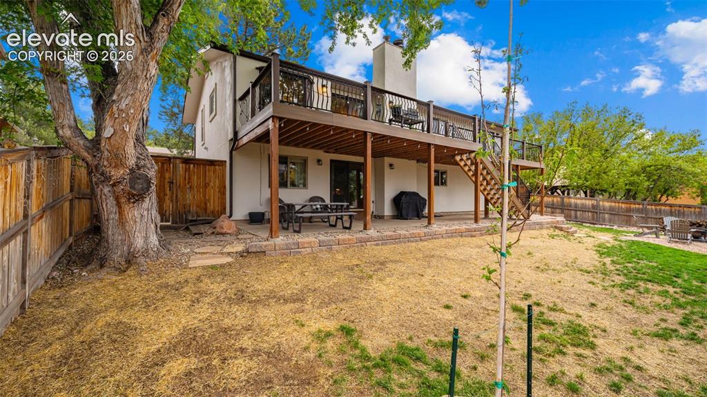 Image 40 of 50: Rear exterior featuring a two-story wood deck with railing, lower level pat
