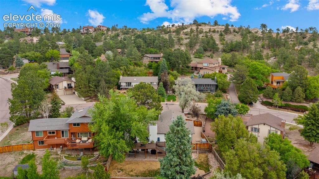 Image 45 of 50: Hillside residential area featuring numerous properties surrounded by matur