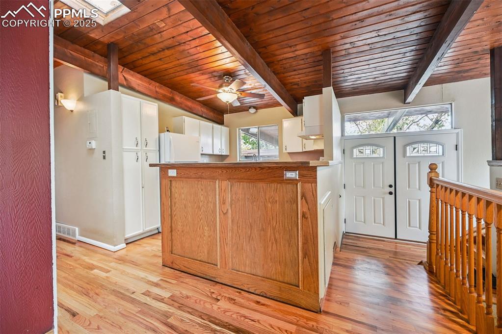 Image 15 of 44: Kitchen featuring light wood finished floors, a wooden ceiling with exposed