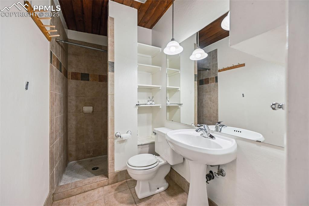 Image 33 of 44: Full bathroom featuring a tile shower and tile patterned floors