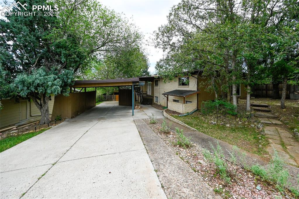 Image 5 of 44: View of front facade with concrete driveway and a carport