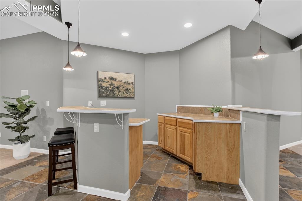 Image 22 of 35: Dry bar with barstool seating