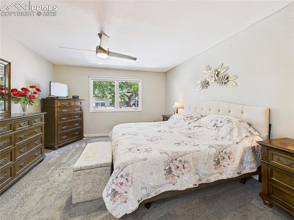 Image 24 of 49: Primary Bedroom – Large picture window frames the landscaped view outside,