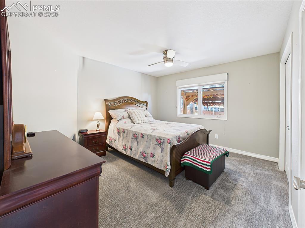 Image 30 of 49: Second Bedroom – Secondary bedroom features a ceiling fan, plush carpet, an