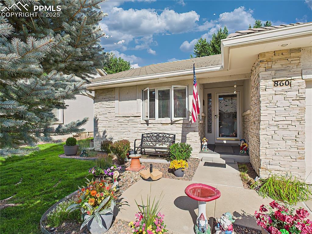 Image 35 of 49: Front Porch – Thoughtfully landscaped entryway with colorful planters, flag