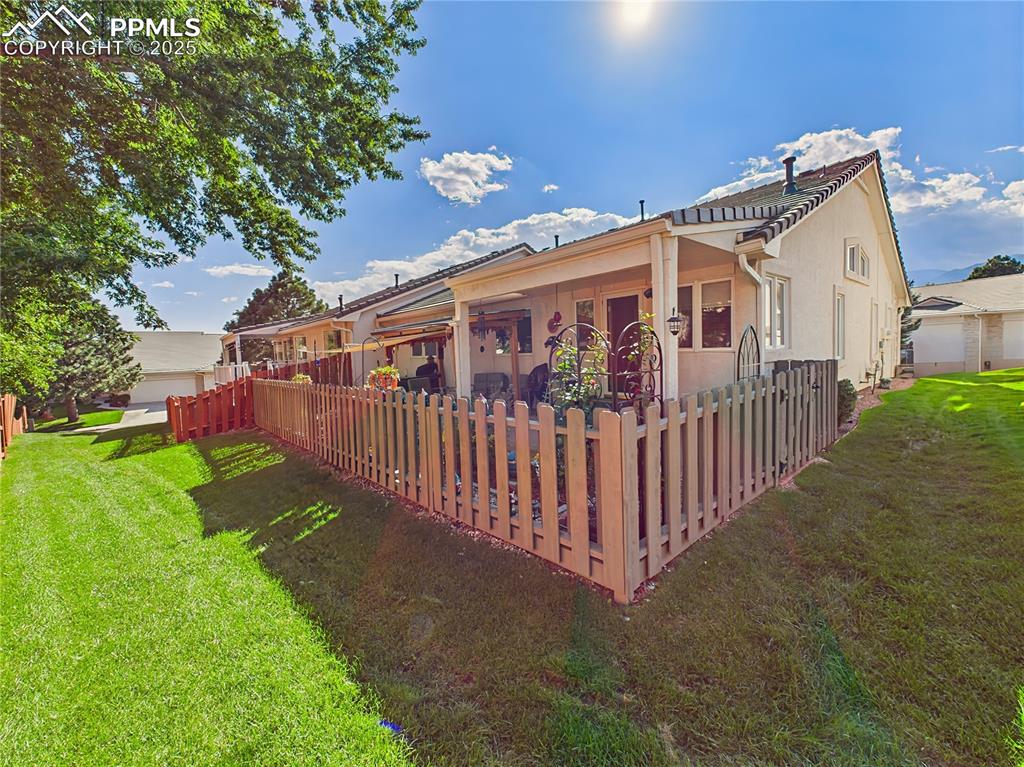 Image 36 of 49: Rear Yard – Fenced backyard with mature trees and privacy fencing, perfect