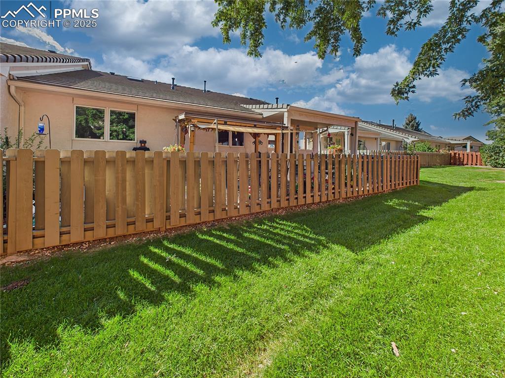 Image 37 of 49: Rear Yard – Beautifully maintained green space and extended fencing surroun