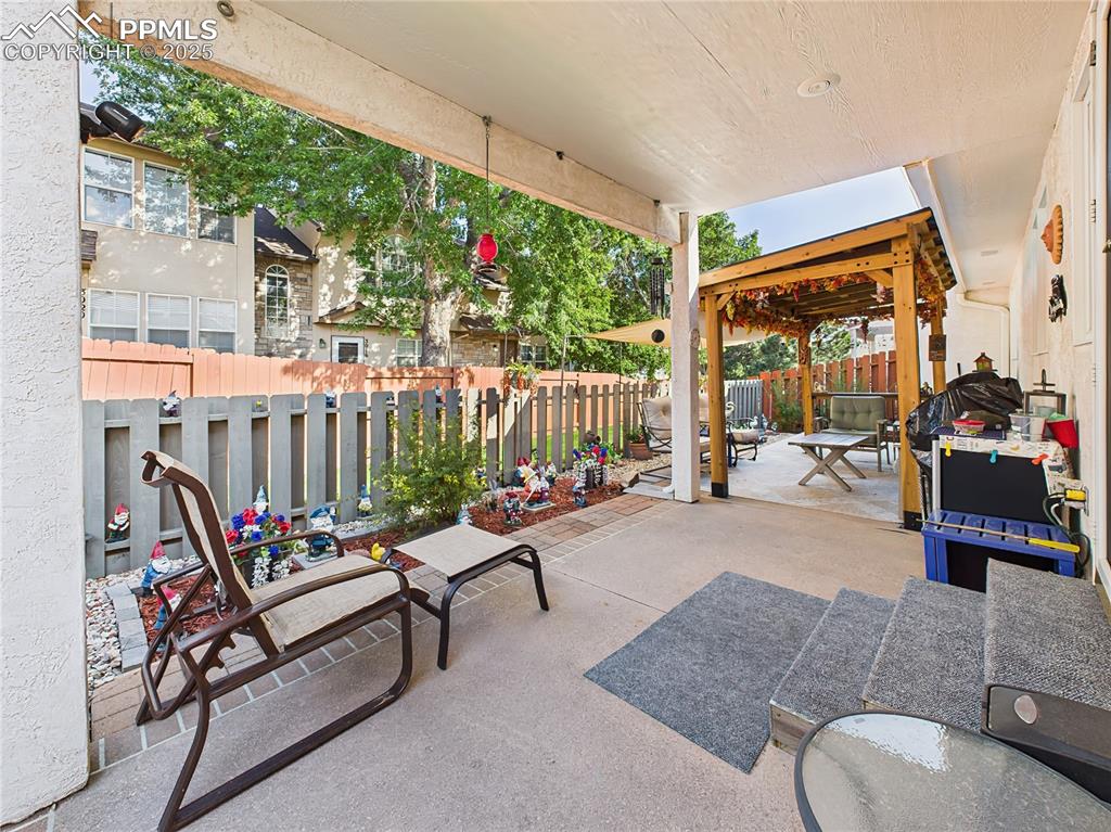 Image 39 of 49: 59. Patio Lounge Area – Concrete and paver patio includes a charming pergol