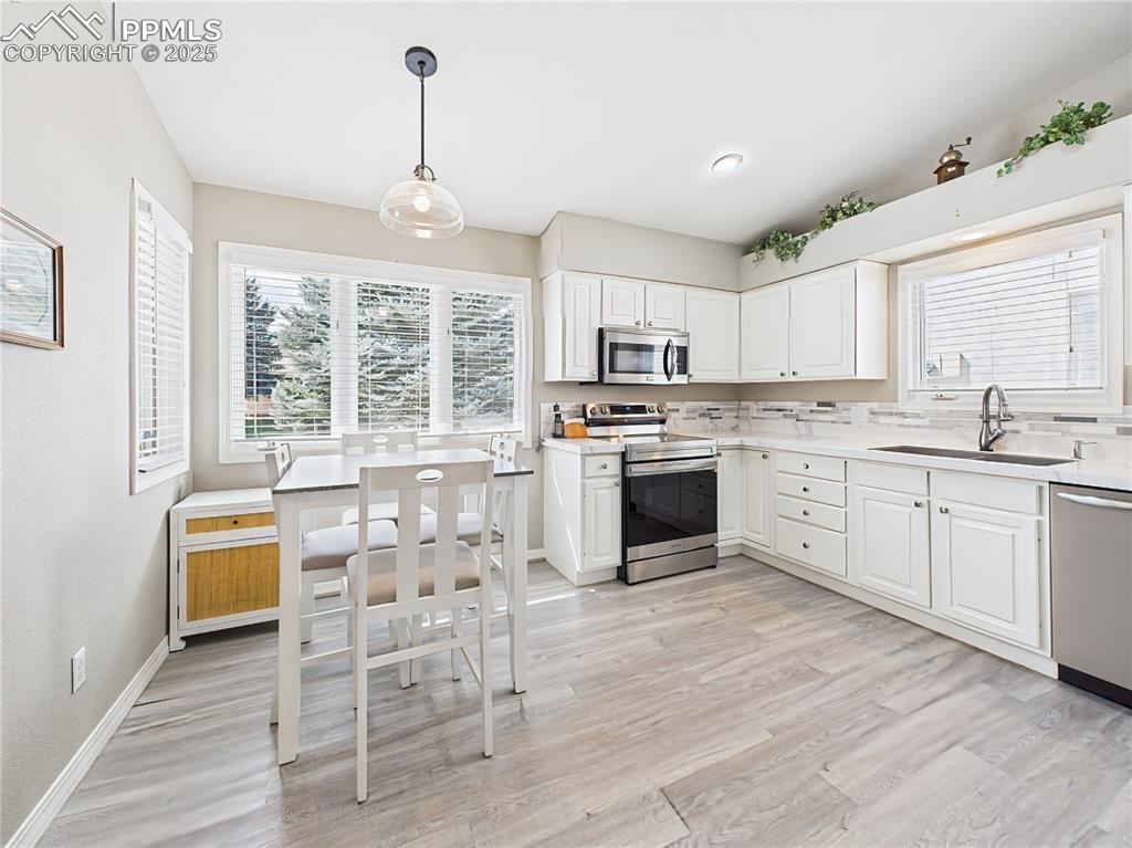 Image 5 of 49: Kitchen & Dining Nook Bright eat-in kitchen with white cabinetry, stainless