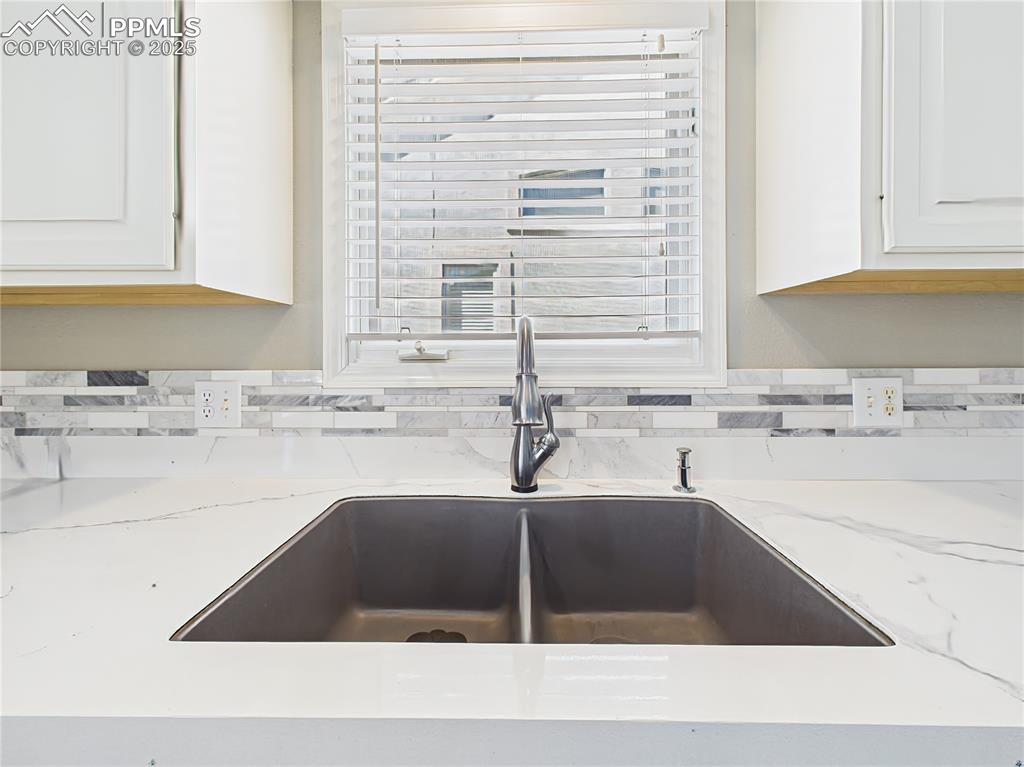 Image 9 of 49: Kitchen Sink Detail – Matte black dual-basin sink with gooseneck faucet, ac