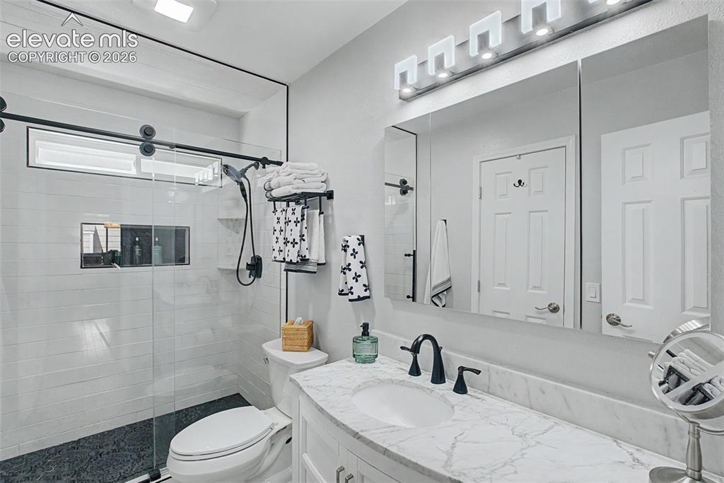 Image 17 of 36: Gorgeous, remodeled bathroom featuring a walk-in shower with inset storage,