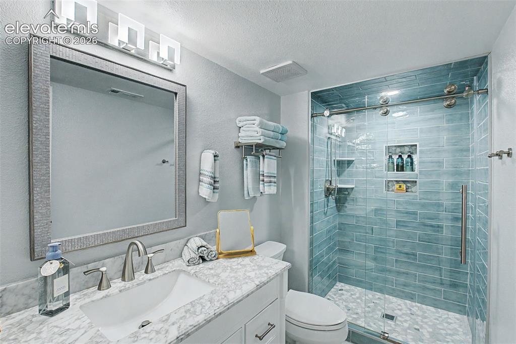 Image 23 of 36: Another beautifully remodeled bathroom featuring a walk-in shower with inse