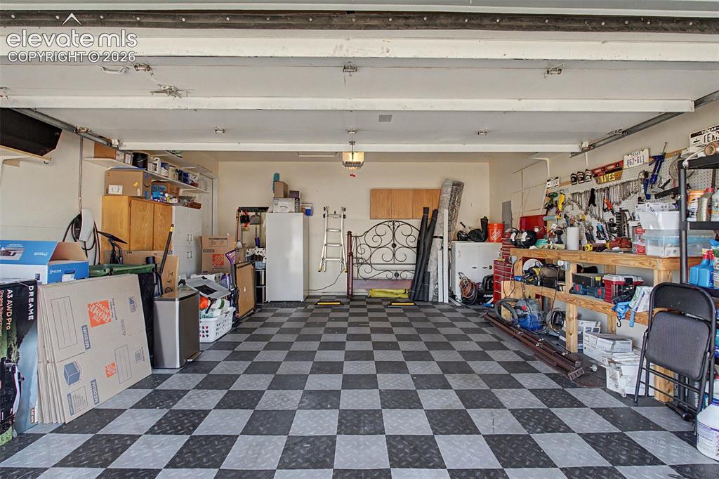 Image 26 of 36: The spacious garage features a Tesla electric vehicle charging station and