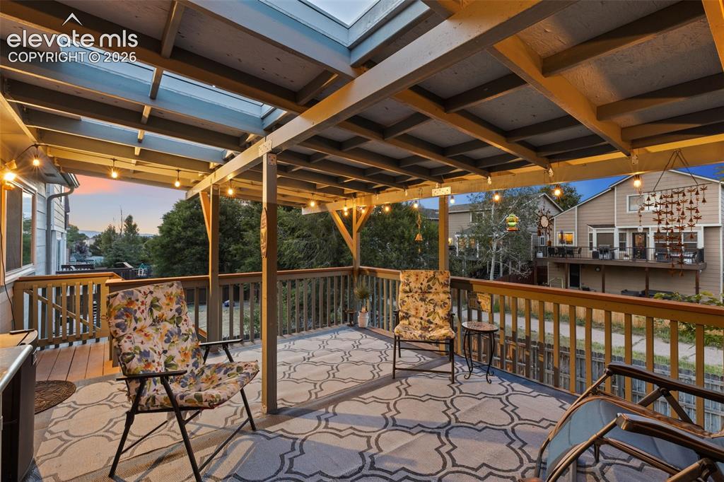 Image 4 of 36: The covered deck is perfect for entertaining or relaxing outdoors, with ste