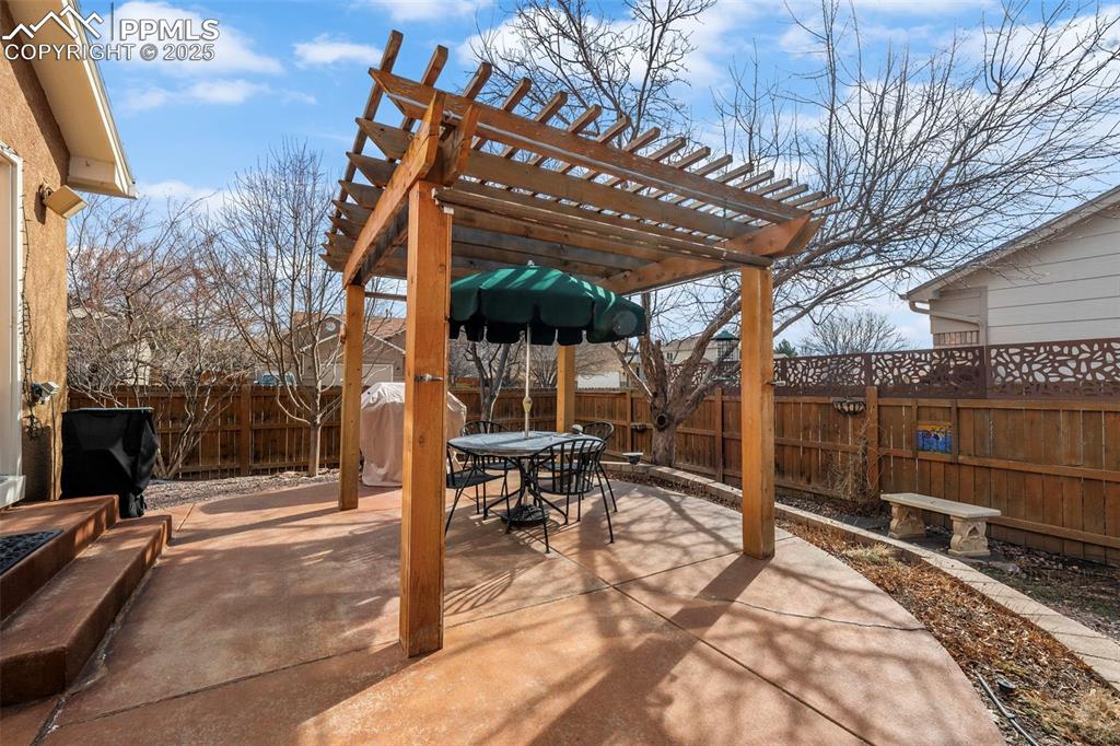 Image 20 of 30: Fenced backyard featuring outdoor dining space, a patio area, and a pergola