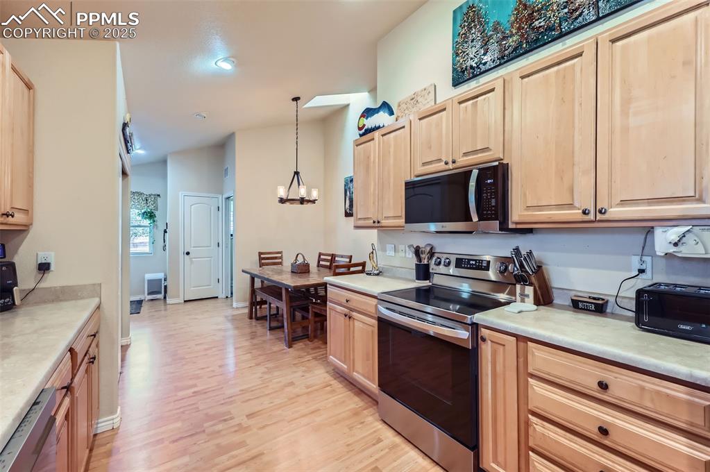 Image 10 of 29: Kitchen featuring appliances with stainless steel finishes, light counterto