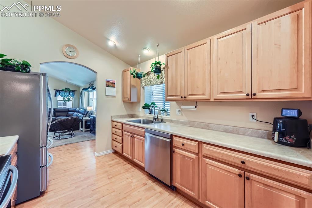 Image 11 of 29: Kitchen featuring lofted ceiling, light wood-style flooring, light countert