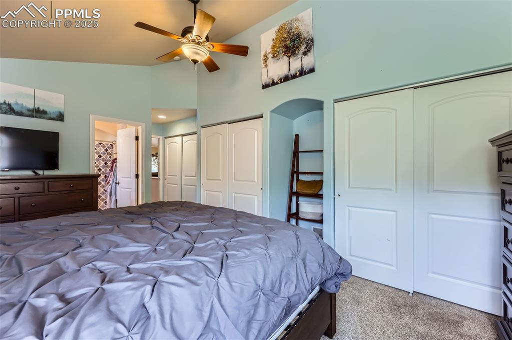 Image 14 of 29: Carpeted bedroom with multiple closets, arched walkways, ensuite bathroom, 