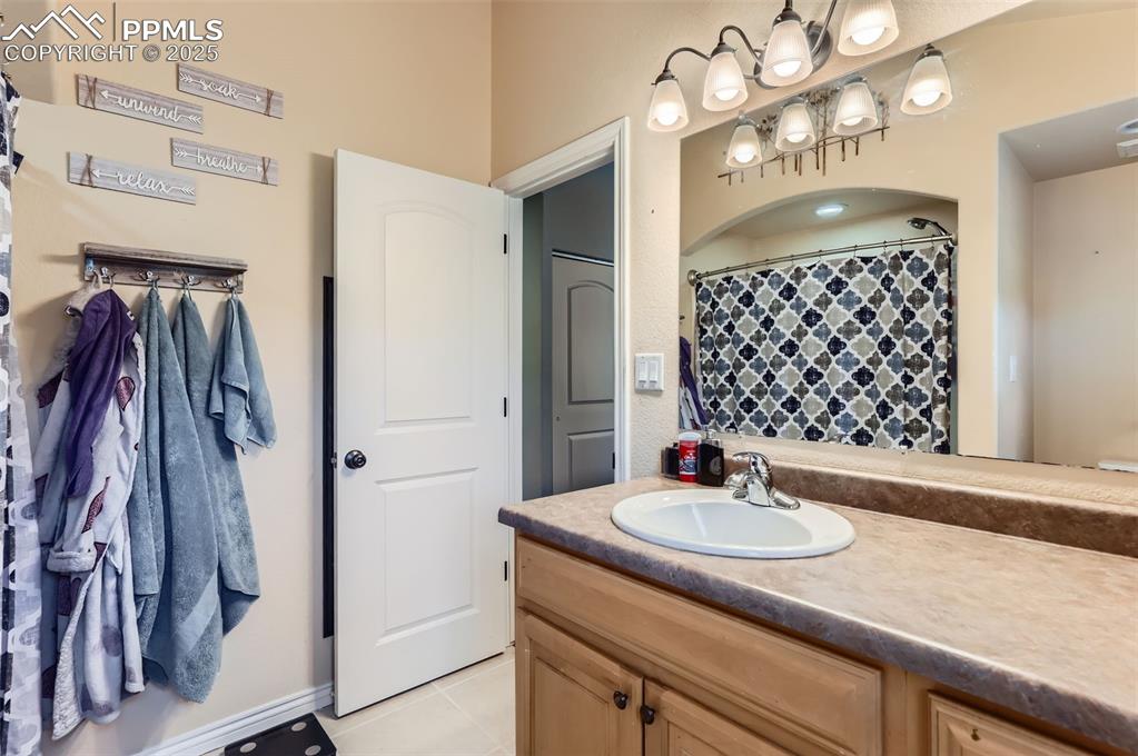 Image 15 of 29: Full bath featuring vanity, light tile patterned flooring, and curtained sh