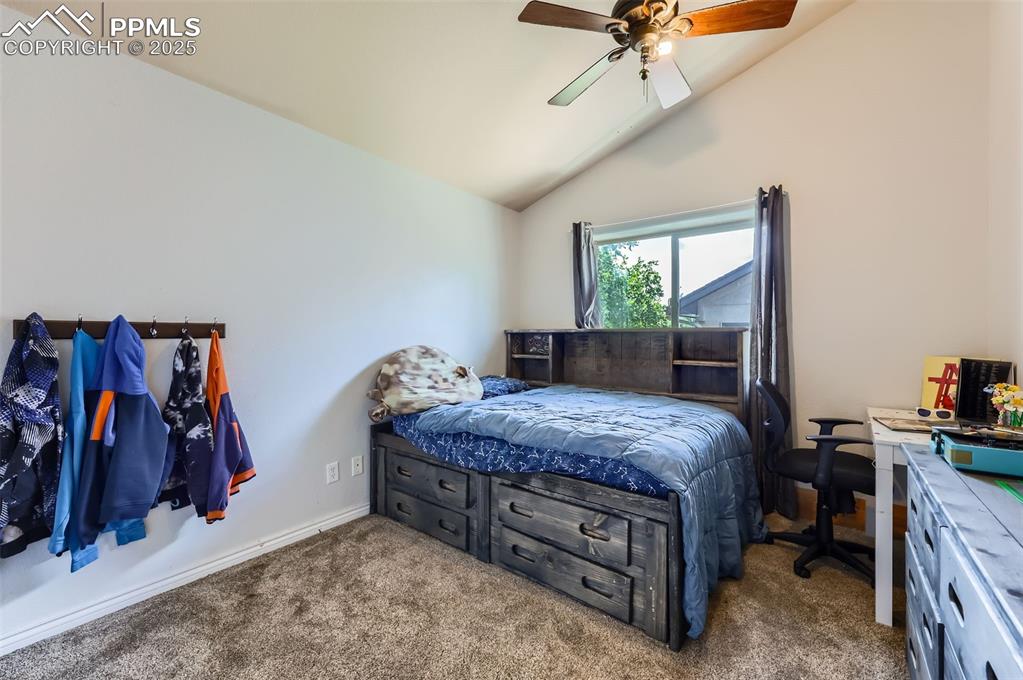 Image 17 of 29: Carpeted bedroom with lofted ceiling and ceiling fan