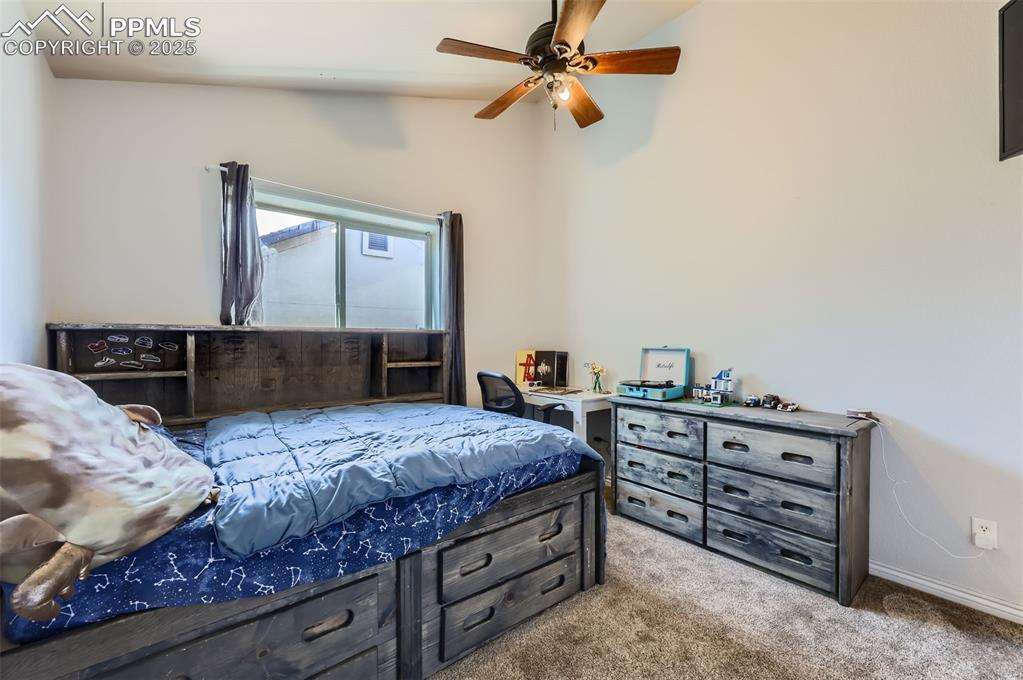 Image 18 of 29: Bedroom with light colored carpet, lofted ceiling, and a ceiling fan
