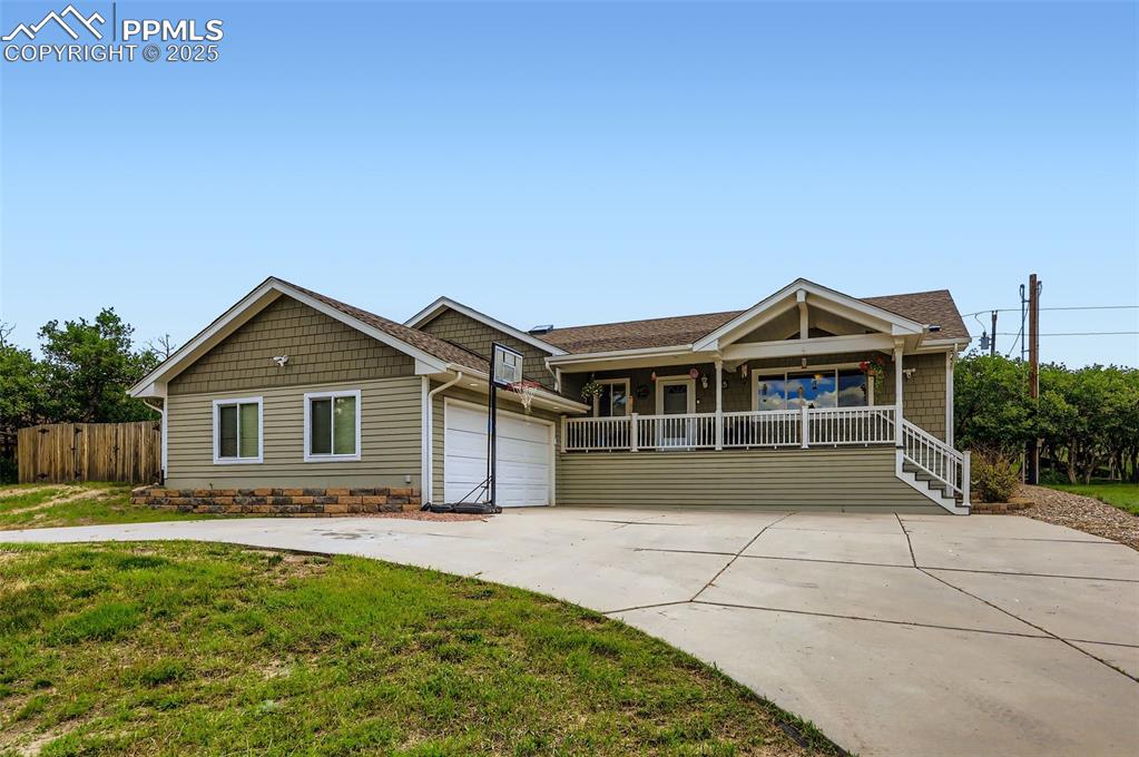 Image 2 of 29: View of front facade featuring driveway, a garage, and covered porch