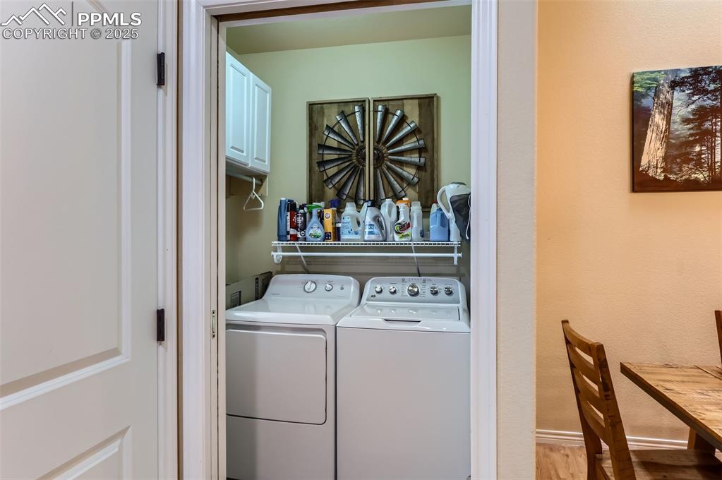 Image 20 of 29: Washroom featuring separate washer and dryer and wood finished floors