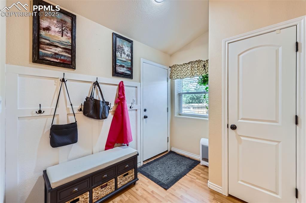 Image 21 of 29: Mudroom featuring lofted ceiling and light wood-style floors