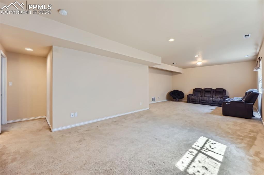 Image 24 of 29: Unfurnished living room with light carpet and recessed lighting