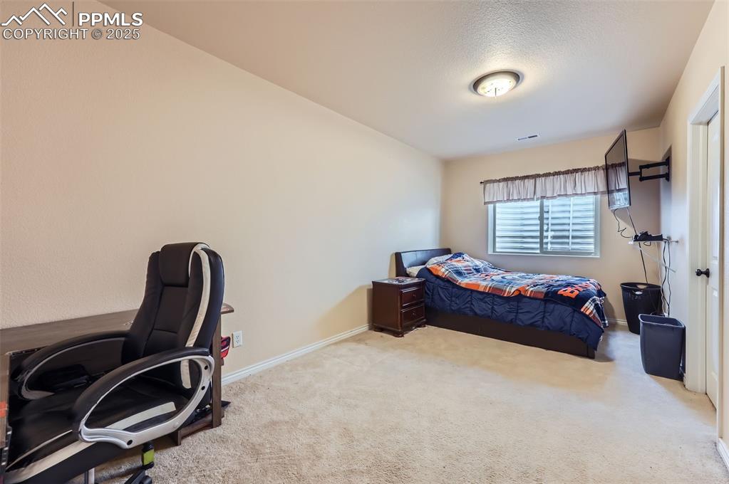 Image 25 of 29: Bedroom featuring carpet floors and an office area