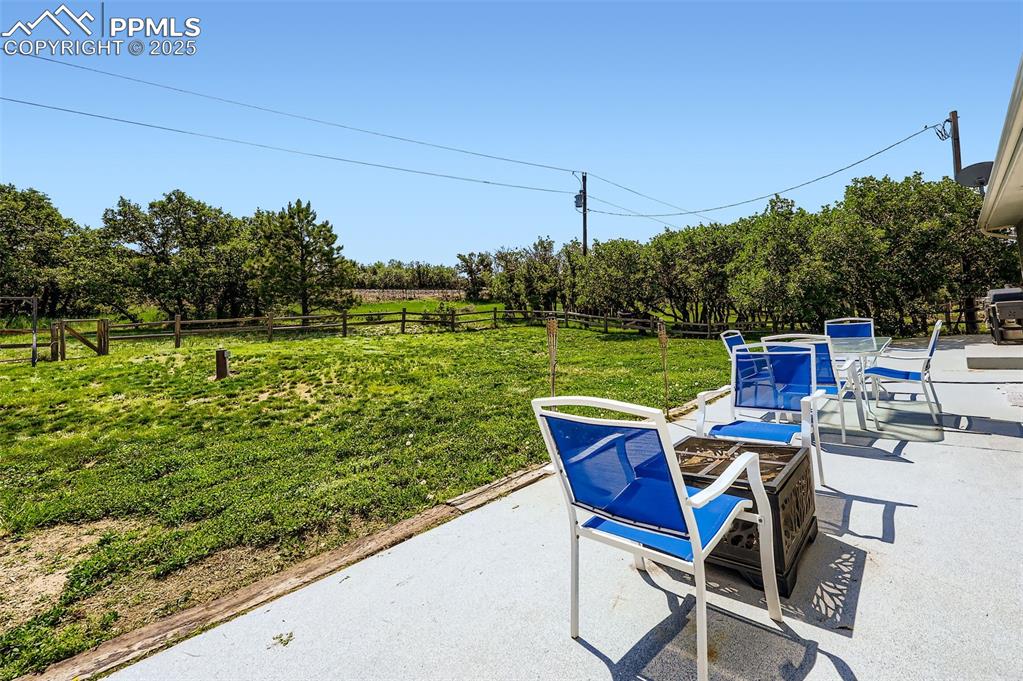 Image 4 of 29: Fenced backyard with a patio area and a fire pit