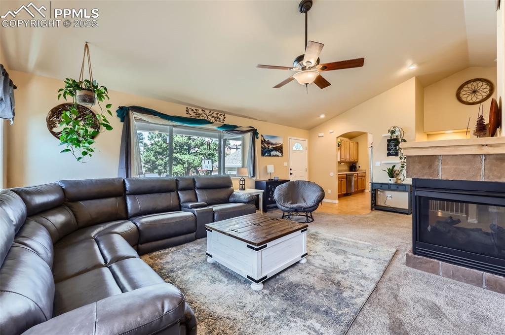 Image 7 of 29: Living room featuring arched walkways, high vaulted ceiling, light colored 