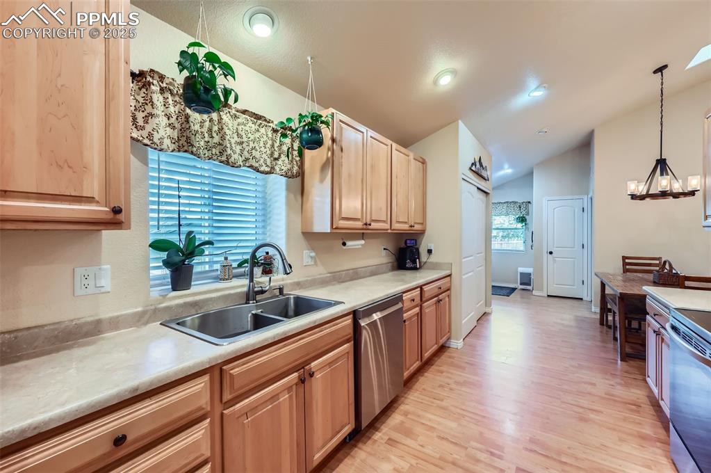 Image 8 of 29: Kitchen with light wood-style flooring, light countertops, stainless steel 