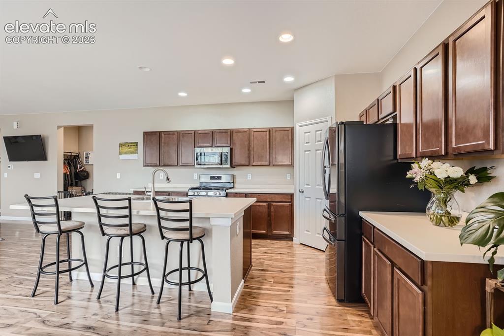 Image 10 of 28: Open-concept kitchen featuring an island with seating, a stainless steel ga