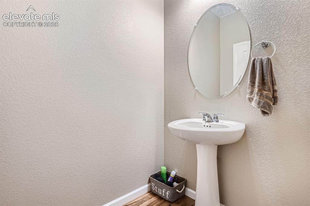 Image 12 of 28: Pedestal sink with chrome faucet, complemented by an oval-shaped mirror