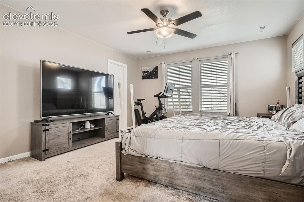 Image 15 of 28: Spacious room featuring neutral carpeting, a ceiling fan with integrated li