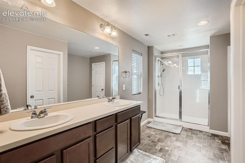 Image 16 of 28: Bathroom featuring a dual vanity with a light-toned countertop, a frameless