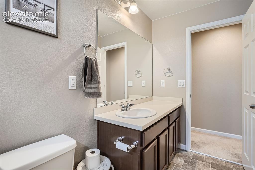 Image 21 of 28: Carpeted room with a ceiling fan light fixture, window with blinds and blue